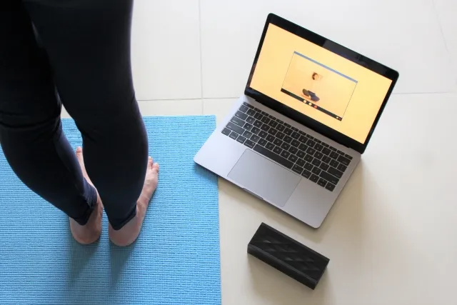 ピラティスの動画を見ながら、マットの上でエクササイズをしているイメージ画像