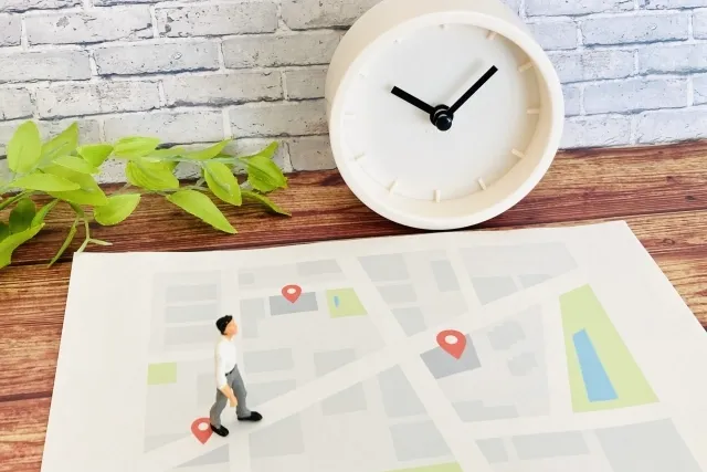 時計とスーツを着た人形と地図でアクセスをイメージした画像