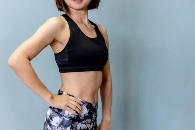 身体をひねって右手を腰に当てている女性