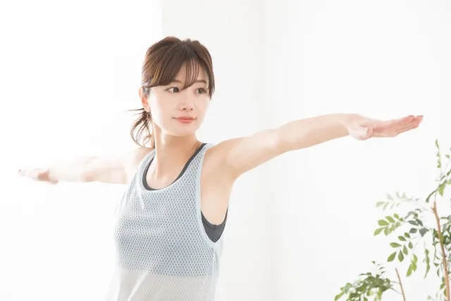 英雄のポーズをしているピラティスウェアを着た女性