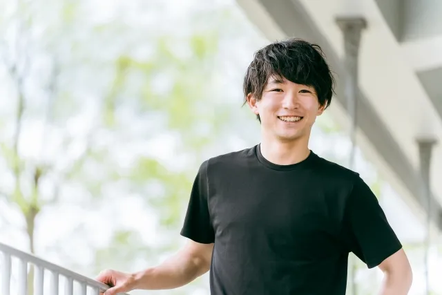 笑顔を見せる黒いトレーニングウェアを着た男性