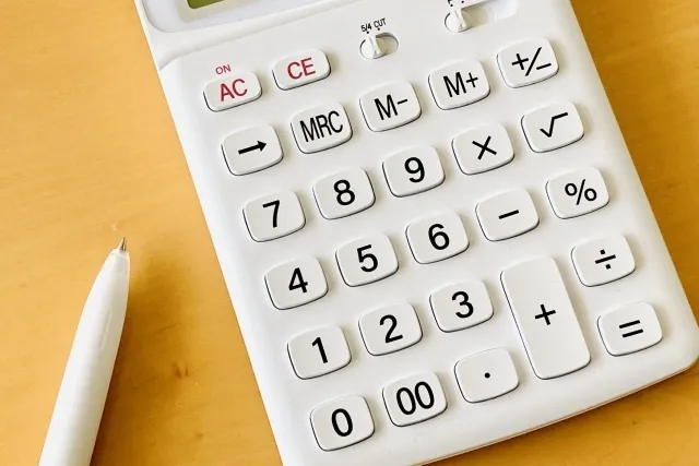 白色の電卓と白色のボールペン